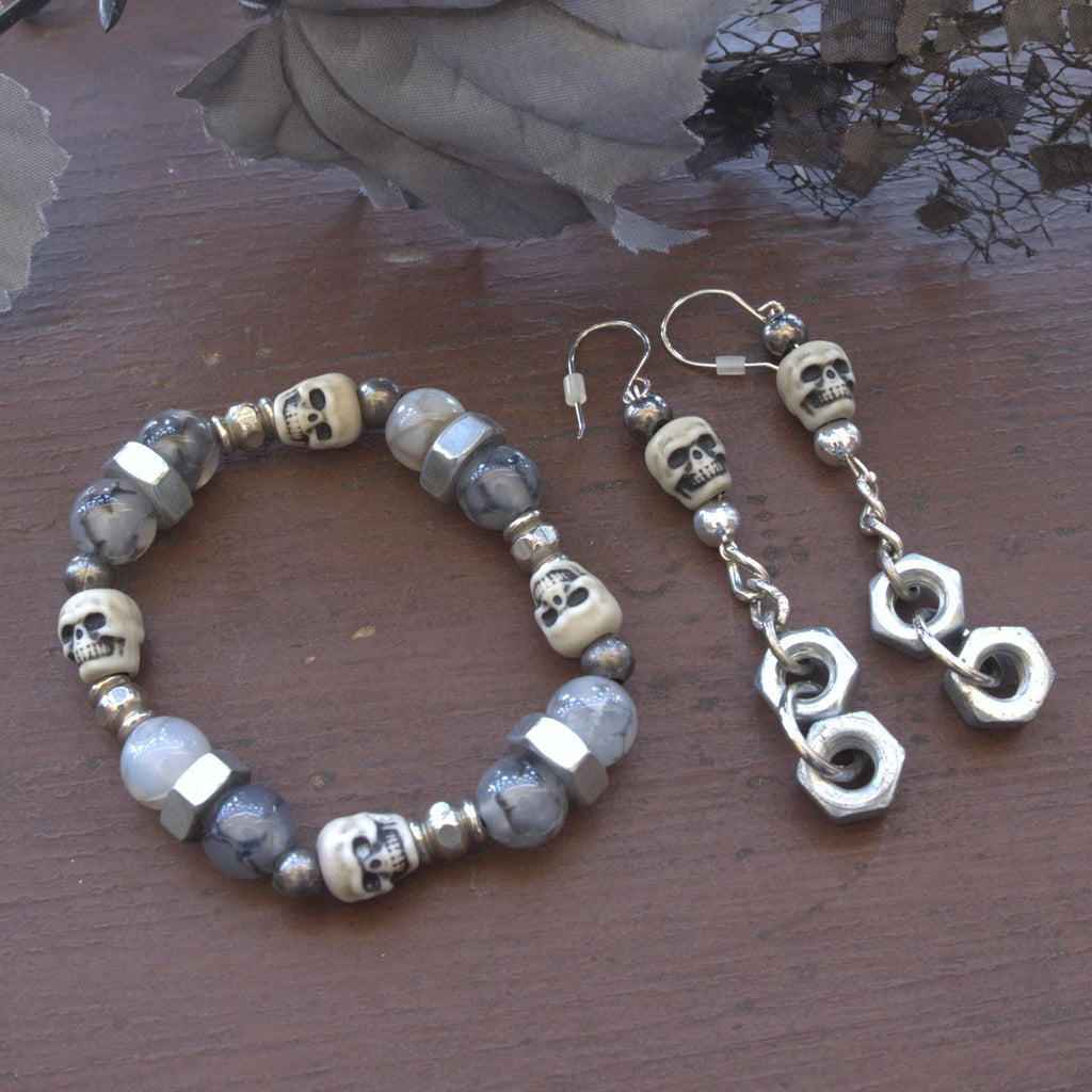 Skull-themed bracelet and earrings on a wooden surface