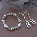 Skull-themed bracelet and earrings on a wooden surface