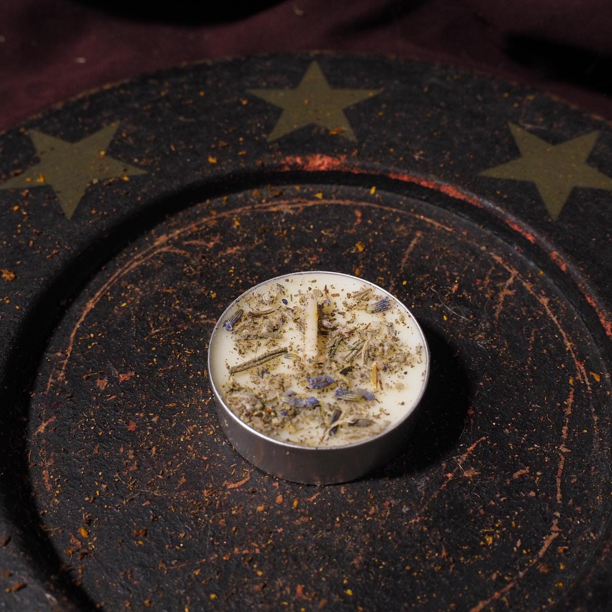 Round candle with decorative elements on a dark surface with star patterns