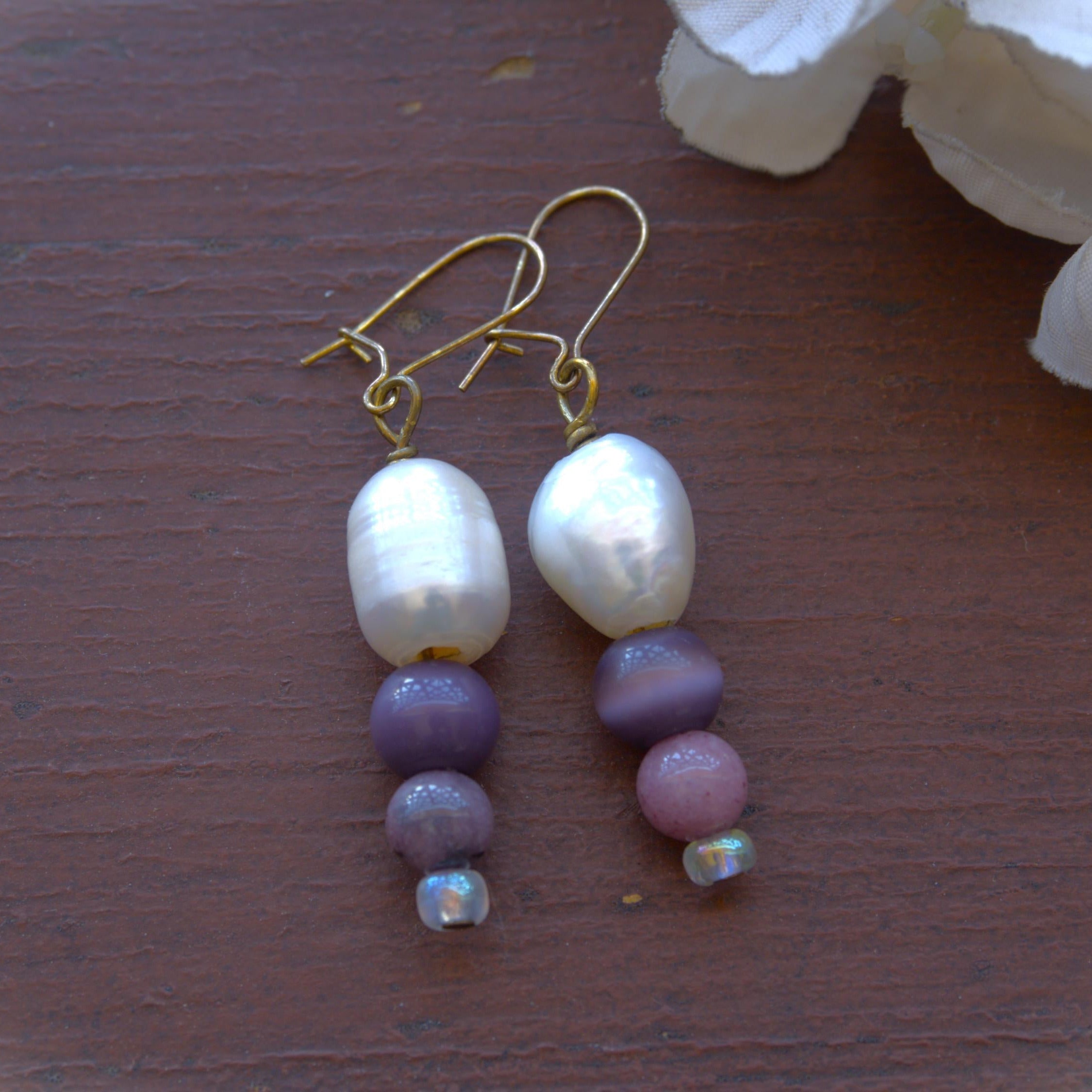 Pearl and bead earrings on a wooden surface